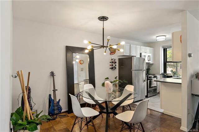 dining room featuring a chandelier and light parquet flooring