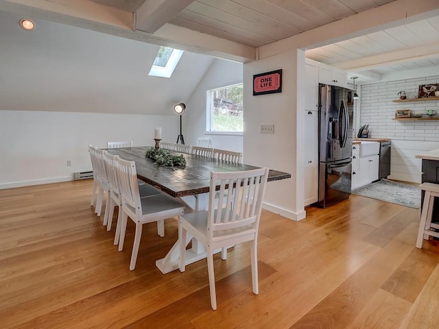 dining area with light hardwood / wood-style flooring, wood ceiling, a baseboard heating unit, and vaulted ceiling with skylight