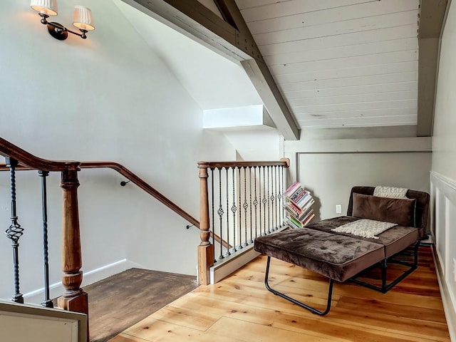 sitting room with lofted ceiling with beams, wood-type flooring, and wood ceiling