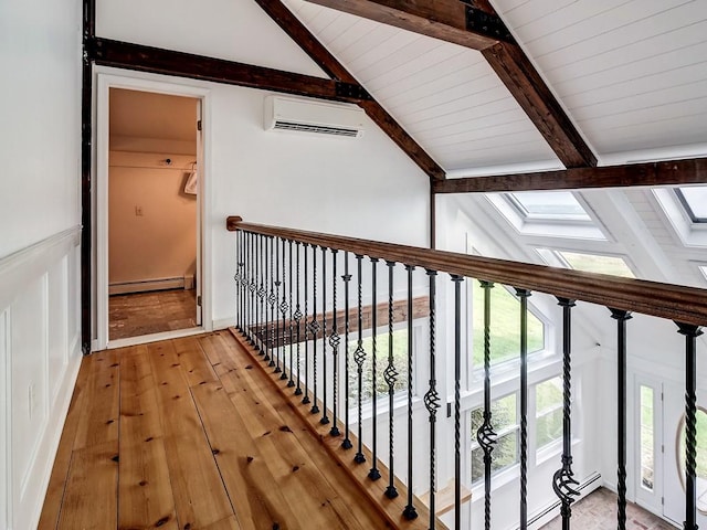 corridor with wooden ceiling, baseboard heating, an AC wall unit, light hardwood / wood-style floors, and vaulted ceiling with skylight