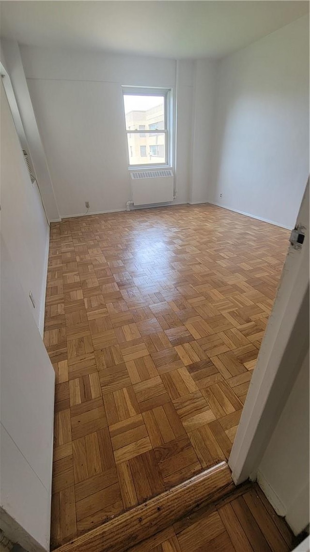 empty room featuring radiator and light parquet flooring