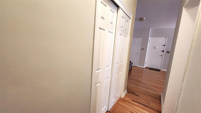 hall with light wood-style floors and baseboards