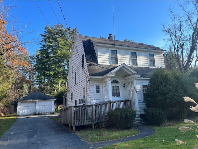 view of front of property featuring an outbuilding, cooling unit, a deck, and a garage