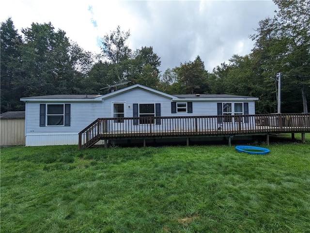 rear view of house with a wooden deck and a yard