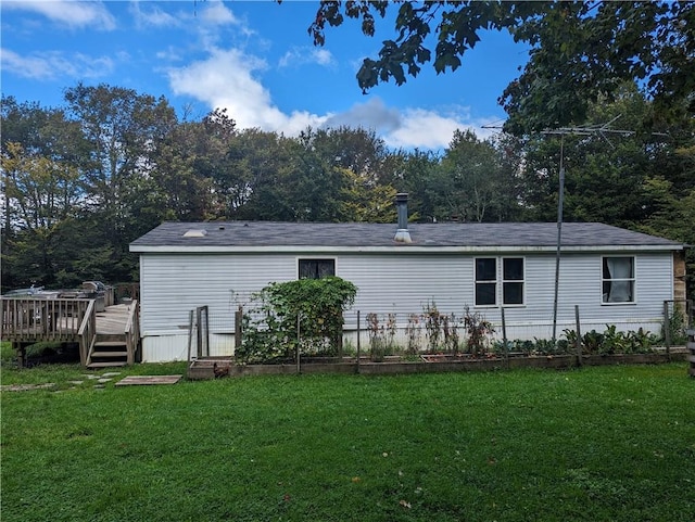 rear view of house featuring a deck and a lawn