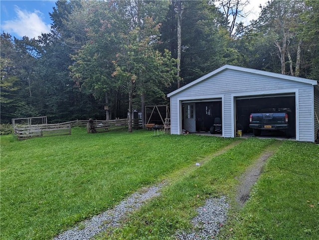 view of yard featuring a garage and an outbuilding