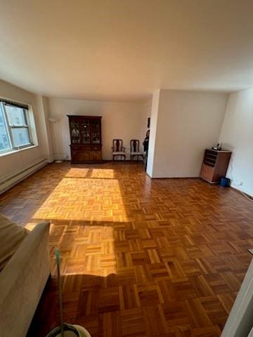 unfurnished living room featuring parquet flooring