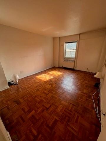 unfurnished room featuring dark parquet floors