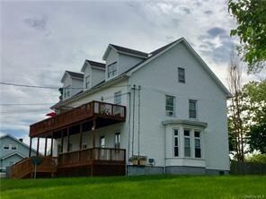 back of property featuring a lawn and a balcony