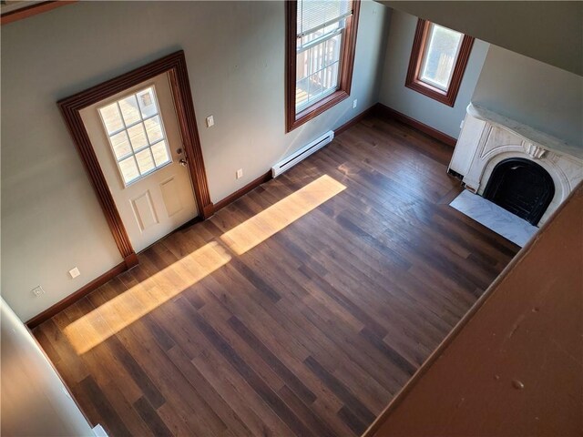 unfurnished living room featuring dark hardwood / wood-style flooring and baseboard heating