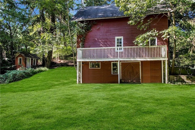 rear view of house featuring a yard and a deck