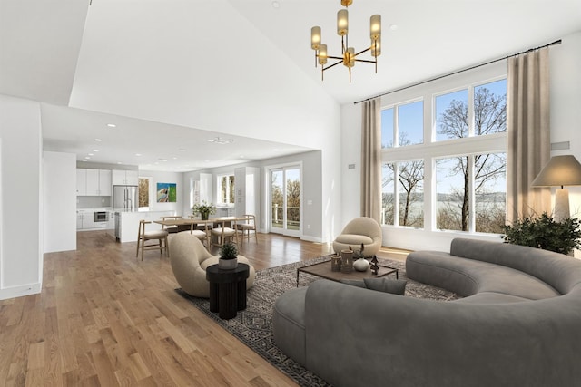 201 Tweed Blvd, Piermont, NY 10960 - living area with light wood finished floors, a chandelier, a towering ceiling, and recessed lighting