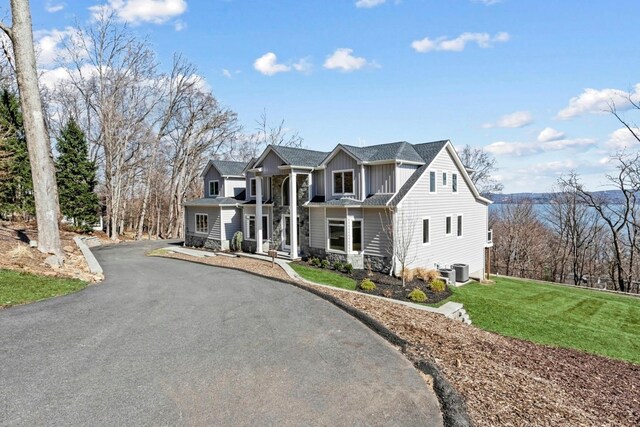 201 Tweed Blvd, Piermont, NY 10960 - view of front of property featuring board and batten siding, asphalt driveway, a front lawn, and stone siding