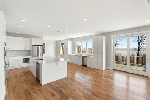 201 Tweed Blvd, Piermont, NY 10960 - kitchen with stainless steel appliances, plenty of natural light, light wood-style flooring, recessed lighting, and a kitchen island with sink