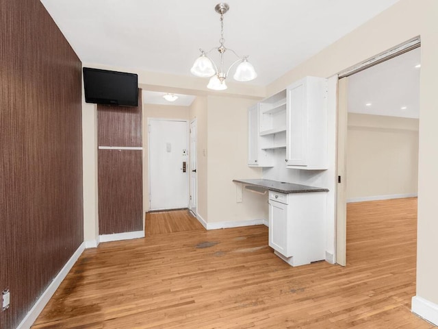 kitchen with open shelves, dark countertops, light wood-style flooring, and white cabinets