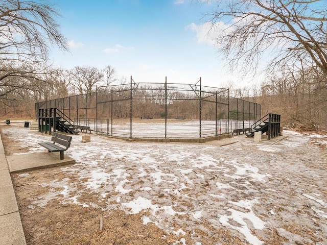 view of community featuring a tennis court and fence