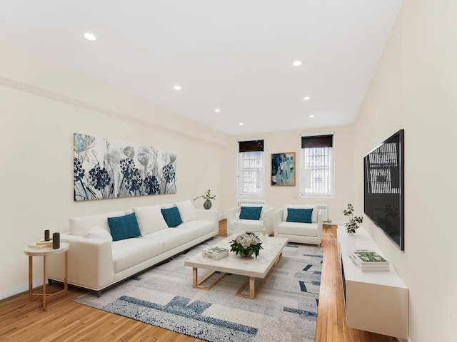 living room with baseboards, wood finished floors, and recessed lighting