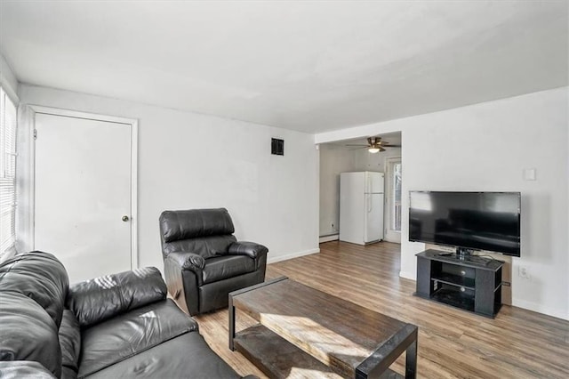 living room with a ceiling fan, wood finished floors, visible vents, and baseboards