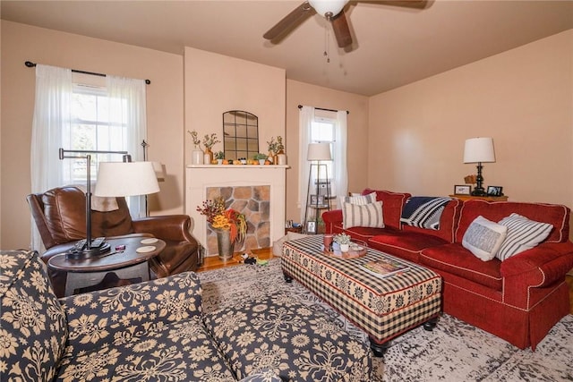 living room featuring a fireplace, hardwood / wood-style floors, and ceiling fan