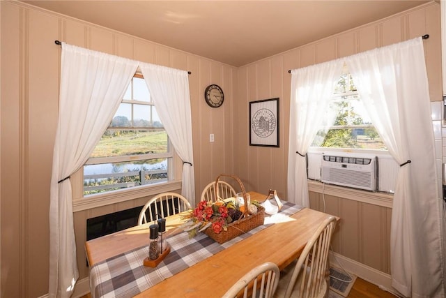 dining room with a water view, hardwood / wood-style flooring, and cooling unit