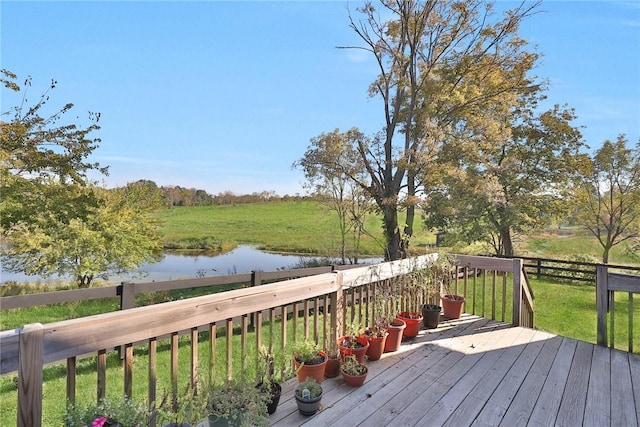 wooden terrace featuring a lawn and a water view