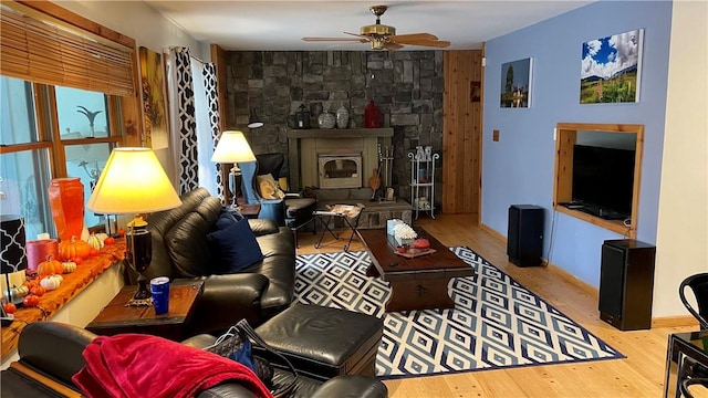 living room with ceiling fan, a fireplace, and light hardwood / wood-style flooring