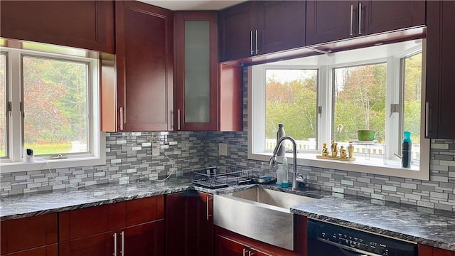 kitchen featuring backsplash, a healthy amount of sunlight, and black dishwasher