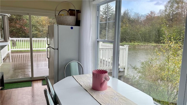 dining room with hardwood / wood-style flooring and a water view