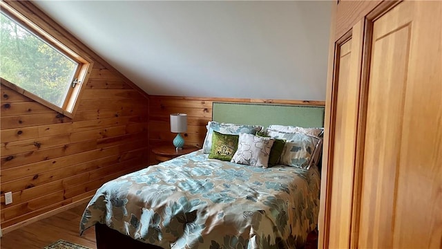 bedroom with wood walls, wood-type flooring, and vaulted ceiling