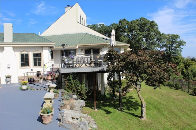 back of house featuring a wooden deck, a yard, and a patio