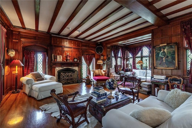 living room featuring wood walls, beamed ceiling, and hardwood / wood-style flooring