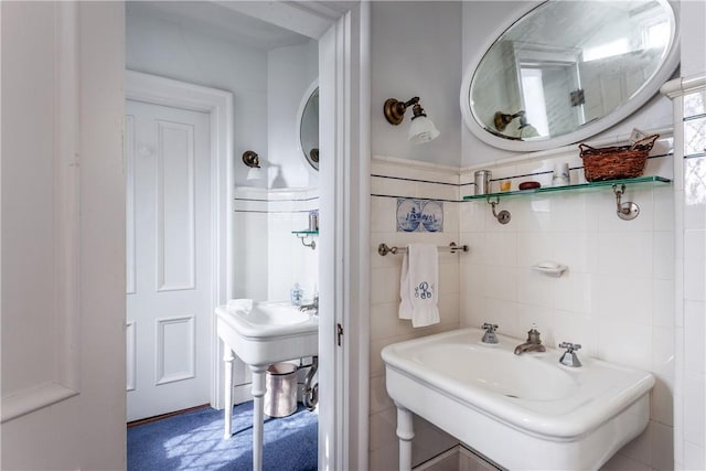 bathroom featuring sink and tile walls