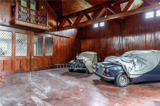 interior space with wood walls, wood-type flooring, and high vaulted ceiling