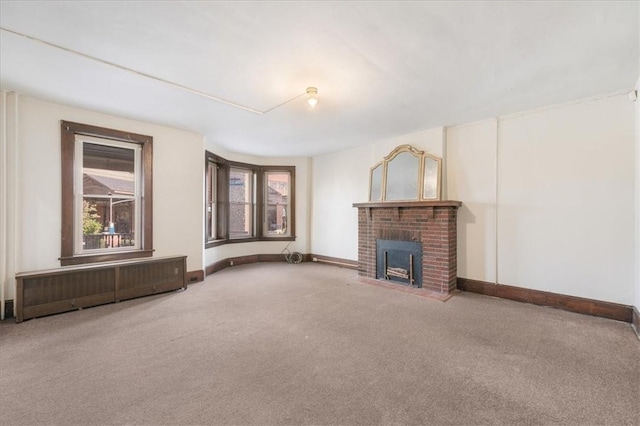 unfurnished living room with a fireplace, radiator heating unit, and carpet floors