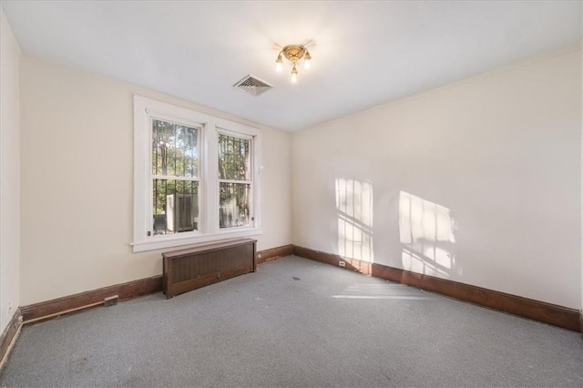 spare room featuring radiator heating unit and carpet floors