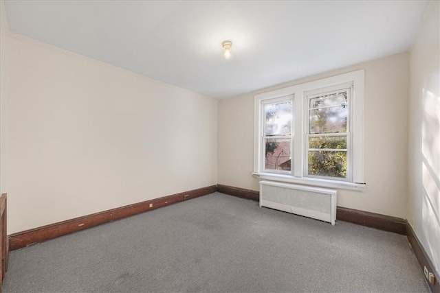 carpeted spare room featuring radiator heating unit and ornamental molding