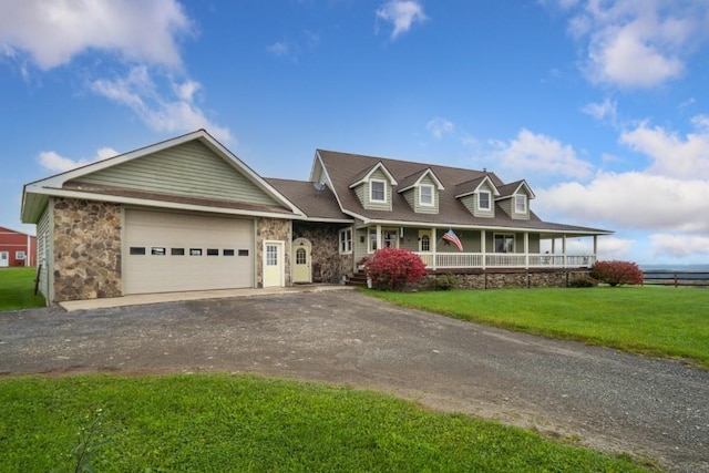 view of front of property featuring covered porch, a front yard, and a garage