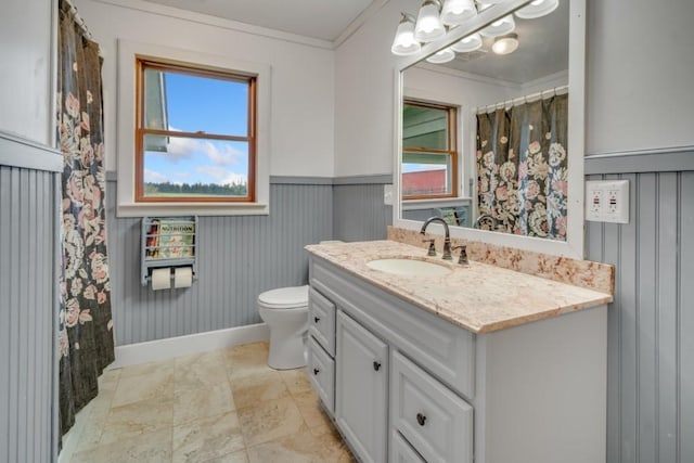 bathroom featuring toilet, vanity, and ornamental molding