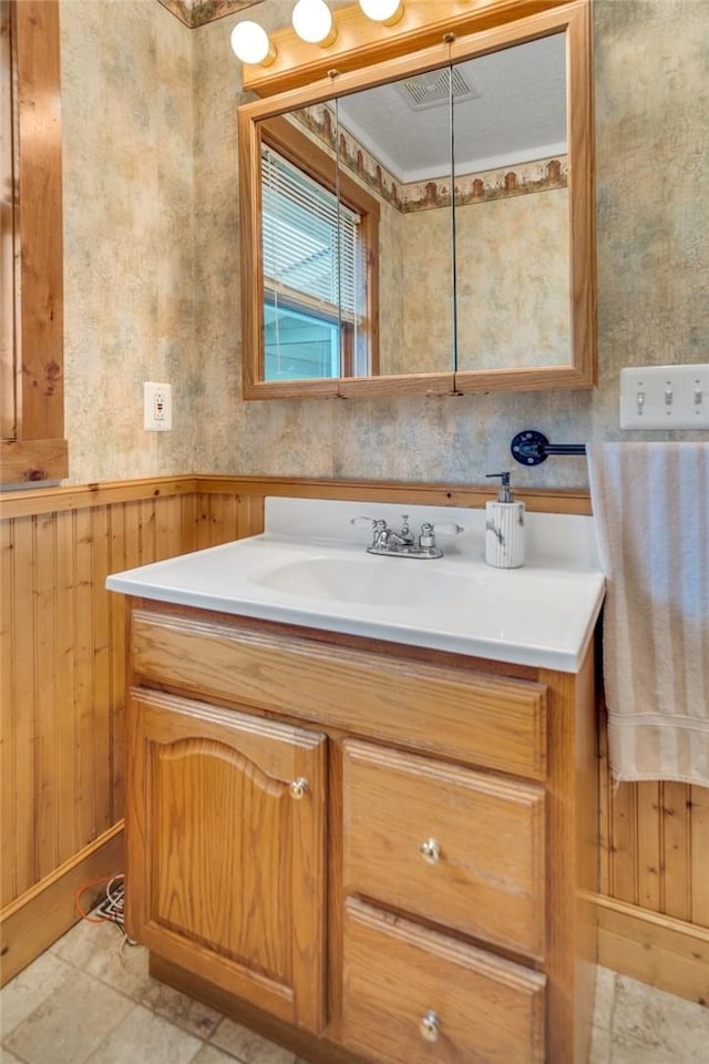 bathroom featuring vanity, tile patterned floors, and wood walls