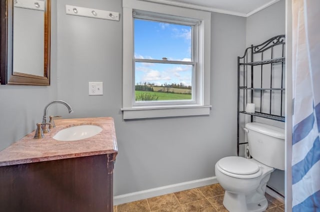 bathroom featuring tile patterned floors, crown molding, vanity, and toilet