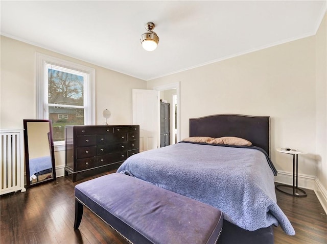 bedroom featuring radiator heating unit, dark hardwood / wood-style flooring, and crown molding