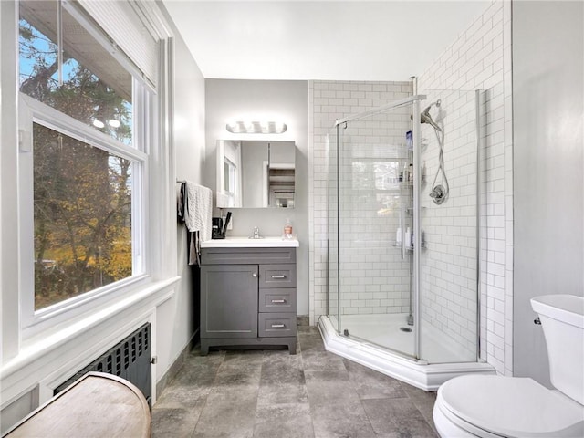 bathroom featuring radiator heating unit, vanity, toilet, and a shower with door