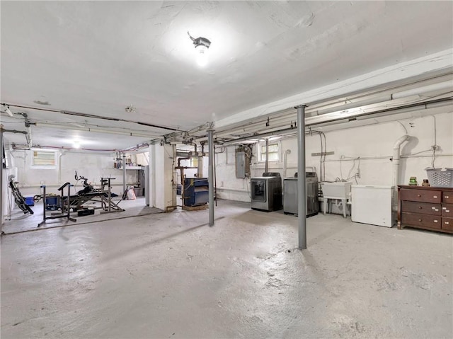 basement with fridge, electric panel, a wealth of natural light, and sink