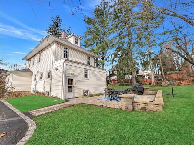 rear view of property featuring a yard and a patio