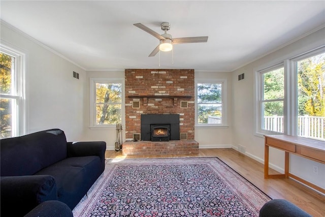 living room featuring ceiling fan, light wood-type flooring, and ornamental molding