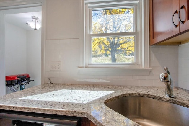 interior space featuring light stone countertops, sink, and a healthy amount of sunlight