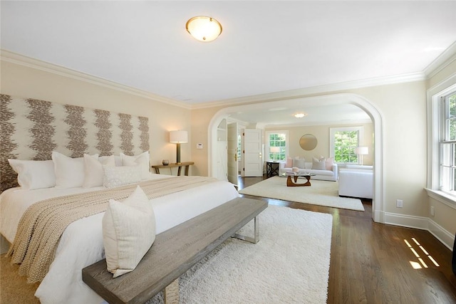 bedroom featuring dark hardwood / wood-style floors, ornamental molding, and multiple windows