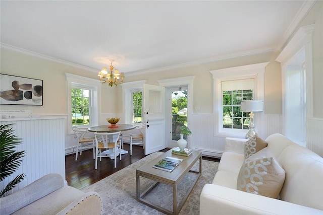 living room with a notable chandelier, a healthy amount of sunlight, wood-type flooring, and ornamental molding