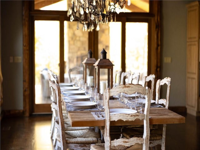 dining space with dark hardwood / wood-style flooring and an inviting chandelier