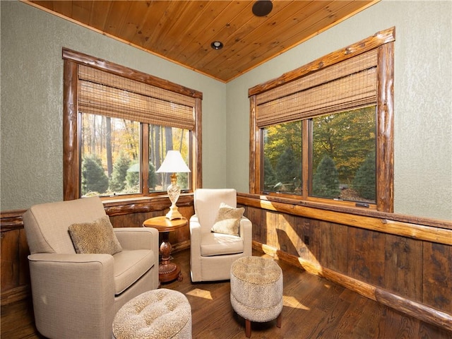 sitting room with hardwood / wood-style flooring, wood walls, and wood ceiling